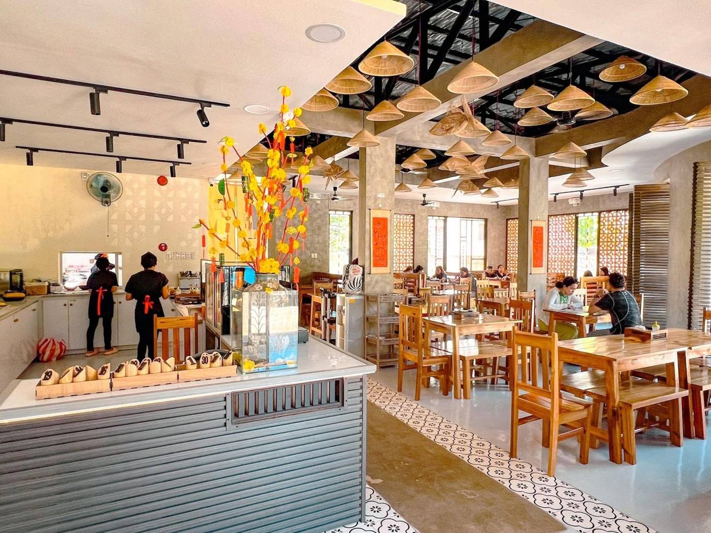 Bright dining hall with yellow blossom display and diners