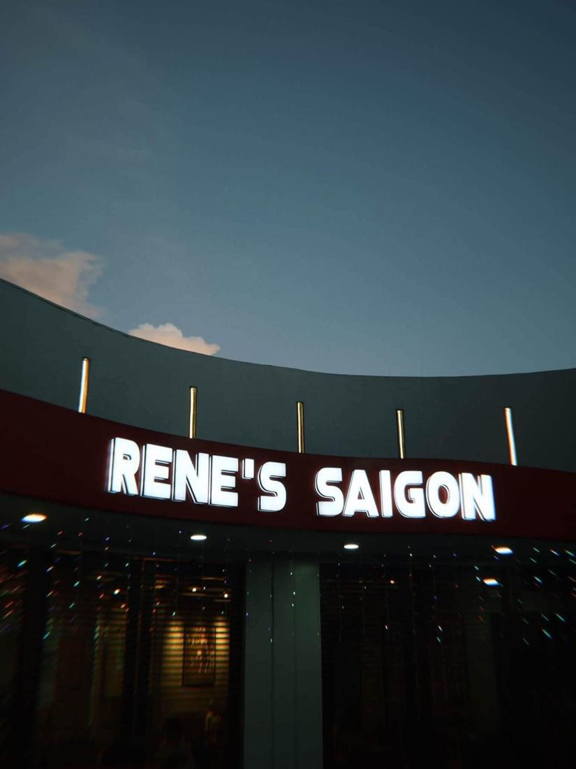 The lit Rene's Saigon sign at dusk